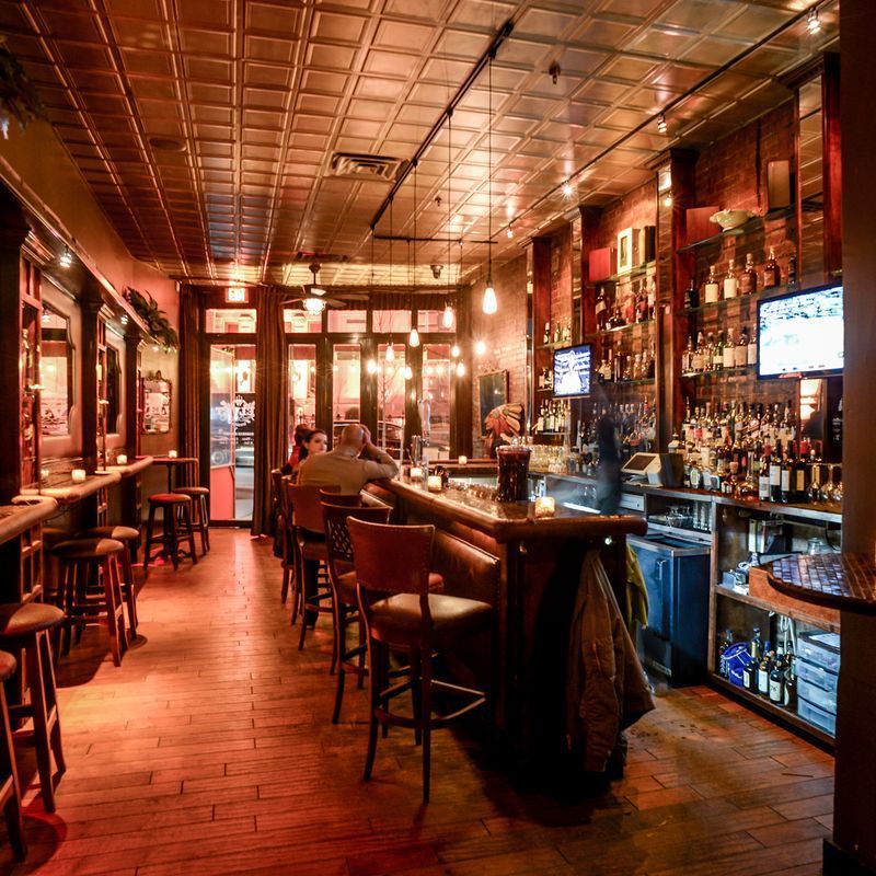 Exposed brick bar room with vintage chandeliers at Velvet Brooklyn in Williamsburg