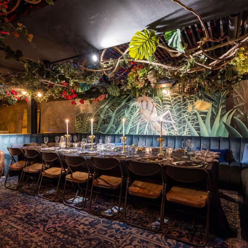 French bistro dining room with exposed beams and greenery at Loulou in Chelsea