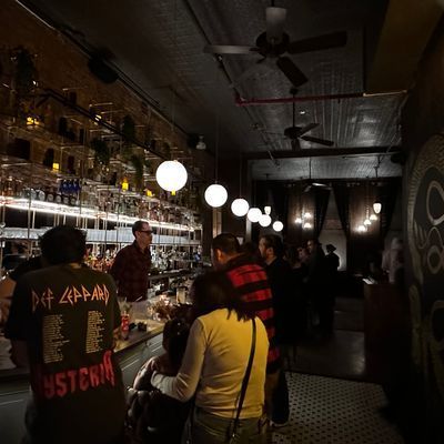 Upstairs bar area at Little More in Tribeca with the marble bar and spirits library