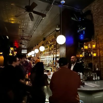 Marble bar and towering spirits library inside Little More in Tribeca