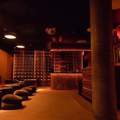 Moody underground lounge with backlit bar shelves at Music For A While in Chelsea