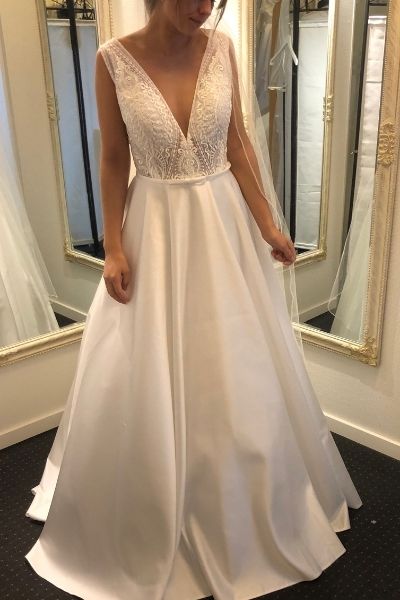 Kayla Dresses - Hvid brudekjole uden ærmer fra Kayla Dresses med blondeoverdel med dyb V-udskæring