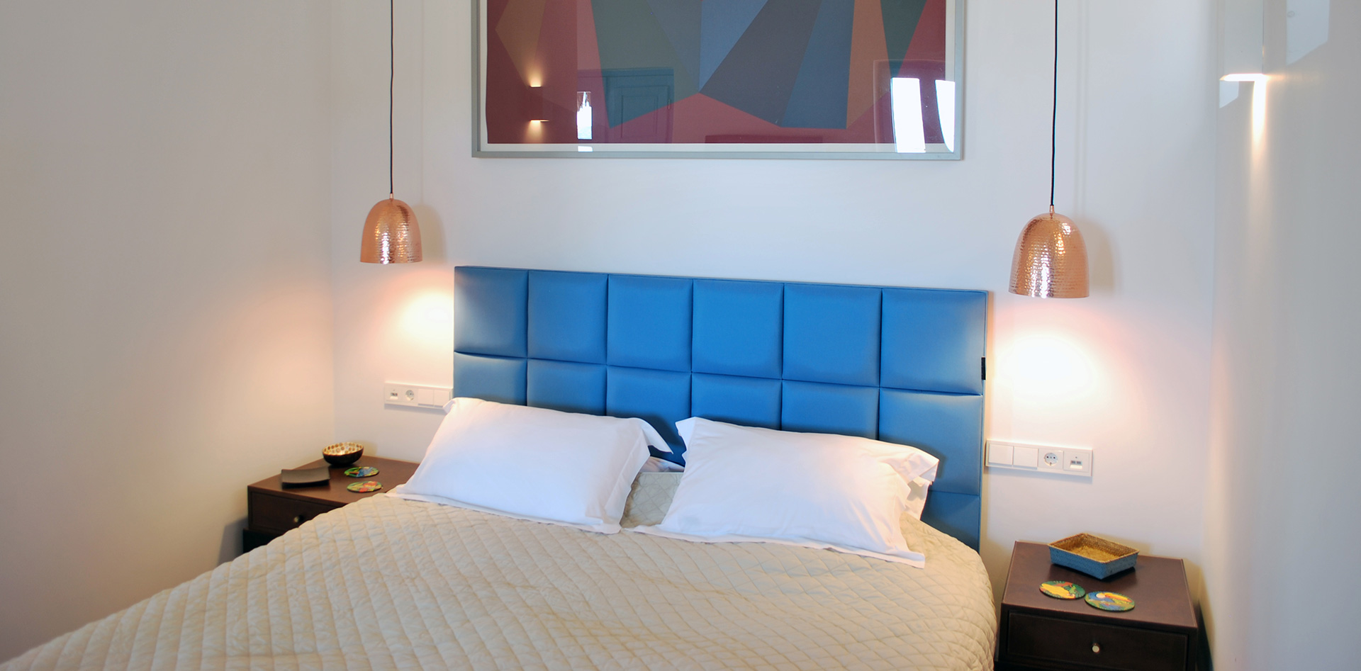 Blue bed with a white headboard