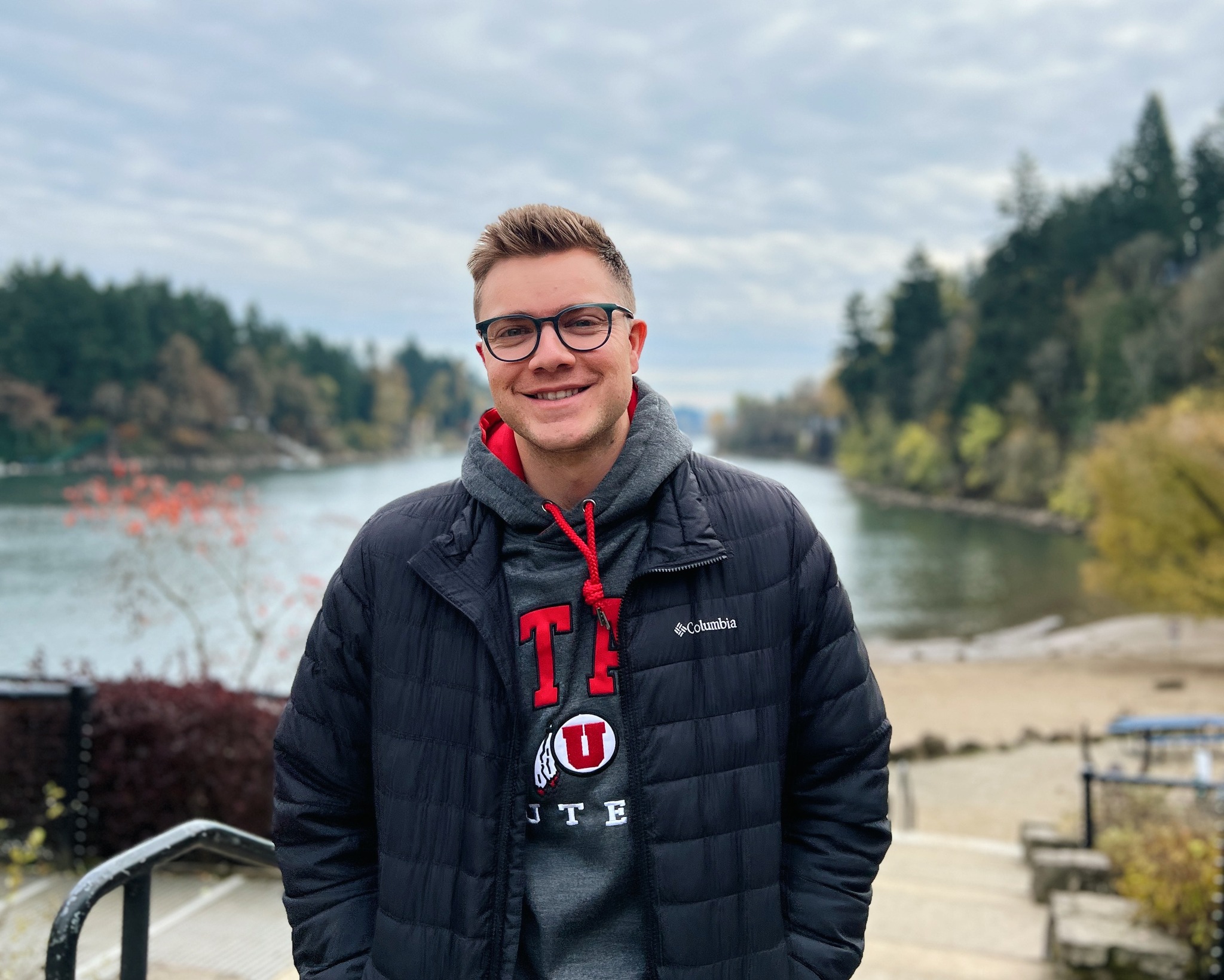 Ben Ahlander smiling in a red plaid shirt and tortoise shell glasses