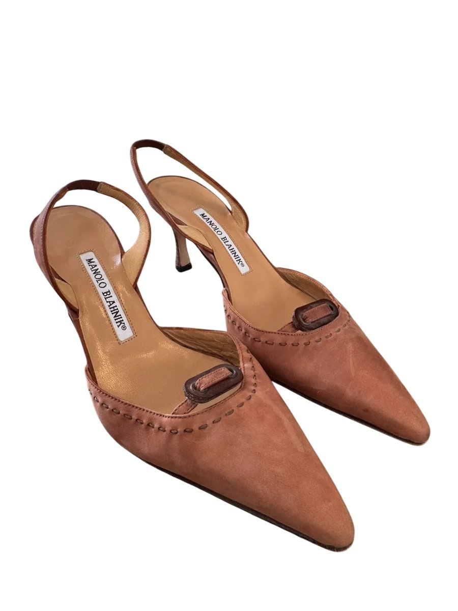 Coral pink pointed-toe slingback heels with kitten heel. Features a suede-like texture and ankle strap with buckle closure. Elegant women's formal footwear displayed on light surface.