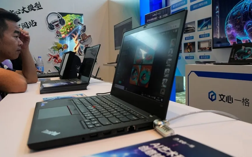 A visitor checks out the AI chatbot Ernie Bot via a laptop computer at a booth promoting the AI chatbot during the Wave Summit in Beijing on Aug. 16, 2023. (AP)