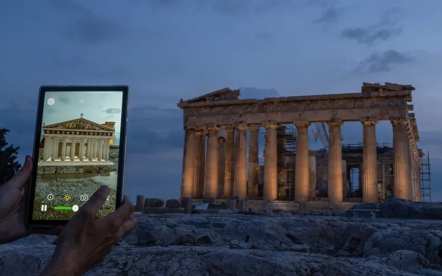 A man holds up a tablet showing a digitally overlayed virtual reconstruction of the ancient Parthenon temple, at the Acropolis Hill in Athens, Greece on Tuesday, June 13, 2023. (AP)