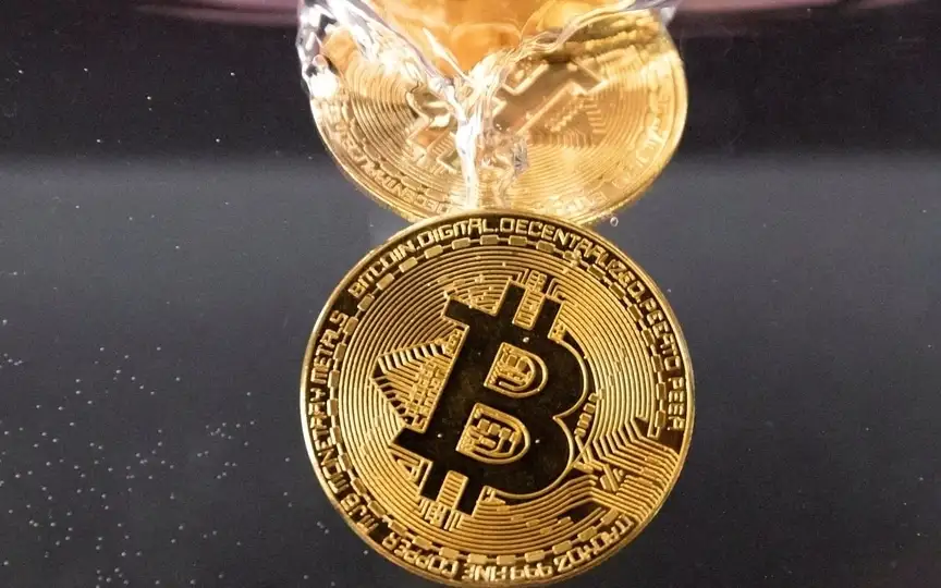 Souvenir tokens representing cryptocurrency Bitcoin plunge into water in this illustration taken May 17, 2022. (REUTERS)