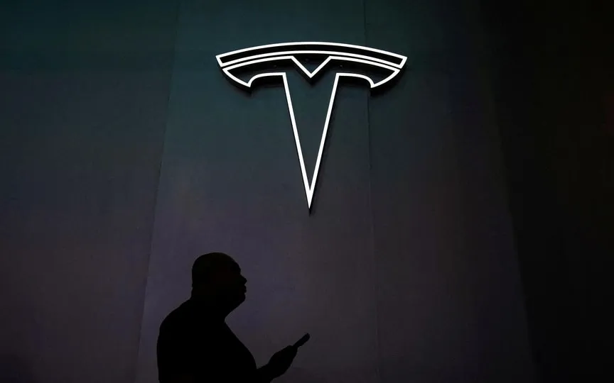 Tesla's stock is underperforming compared to other tech stocks in the market due to concerns about slowing demand for electric vehicles and its lack of association with artificial intelligence. (REUTERS)