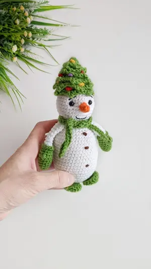 Crochet snowman in a Christmas tree hat amigurumi pattern