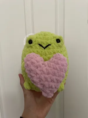 Chubby frog holding a heart crochet pattern