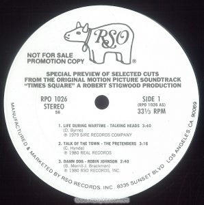 White label record promoting the "Times Square" soundtrack album Text: RSO ® NOT FOR SALE PROMOTION COPY SPECIAL PREVIEW OF SELECTED CUTS FROM THE ORIGINAL MOTION PICTURE SOUNDTRACK "TIMES SQUARE" A ROBERT STIGWOOD PRODUCTION RPO 1026 STEREO 56 SIDE 1 (RPO 1026 AS) 33? RPM 1. LIFE DURING WARTIME - TALKING HEADS 3:40 (D. Byrne) ? 1979 SIRE RECORDS COMPANY 2. TALK OF THE TOWN - THE PRETENDERS 3:16 (C. Hynde) ? 1980 REAL RECORDS 3. DAMN DOG - ROBIN JOHNSON 2:40 (B. Mernit-J. Brackman) ? 1980 RSO RECORDS MANUFACTURED & MARKETED BY RSO RECORDS, INC. 8335 SUNSET BLVD. LOS ANGELES, CA. 90069 [This digital surrogate created by Sean Rockoff for robinjohnson.net.]