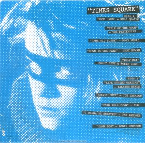 A blue pixellated image of Robin Johnson. Text: "TIMES SQUARE" Side 1 "ROCK HARD" - SUZI QUATRO. PRODUCED BY MIKE CHAPMAN (by Mike Chapman and Nicky Chinn; Chinnichap Publishing Inc. Admin. in the U.S.A. & Canada bv Careers Music Inc.) (BMI) (COURTESY OF DREAMLAND RECORDS, INC.) ℗ 1980 DREAMLAND RECORDS, INC. "TALK OF THE TOWN" - THE PRETENDERS PRODUCED BY CHRIS THOMAS (by Chrissie Hynde; Al Gallico Music Corp. (BMI) (COURTESY OF SIRE RECORDS, INC. /REAL RECORDS) ℗ 1980 REAL RECORDS "SAME OLD SCENE" - ROXY MUSIC PRODUCED BY ROXY MUSIC AND RHETT DAVIES (by Bryan Ferry; E.G. Music, Inc.) (BMI) (COURTESY OF E.G. RECORDS, LTD. /ATLANTIC RECORDING CORP. / POLYDOR INTERNATIONAL) ℗ 1980 ATLANTIC RECORDING CORPORATION "DOWN IN THE PARK" - GARY NUMAN PRODUCED BY GARY NUMAN (by Gary Numan; Geoff & Eddie Music, Inc. and Blackwood Music Inc.) (BMI) (COURTESY OF WEA RECORDS, LTD. /BEGGARS BANQUET LIMITED) ℗1979 A BEGGARS BANQUET RECORDING "HELP ME!" - MARCY LEVY &ROBIN GIBB PRODUCED BY ROBIN GIBB AND BLUE WEAVER (by Robin Gibb and Blue Weaver; Stigwood Music, Inc. (Unichappell Music, Admin.) (BMI) ℗ 1980 YAM, INC. Side 2 "LIFE DURING WARTIME" - TALKING HEADS PRODUCED BY BRIAN ENO AND TALKING HEADS (by David Byrne ; Index Music /Bleu Disque Music Co. Inc.) (ASCAP) (COURTESY OF SIRE RECORDS, INC. /REAL RECORDS) ℗ 1979 SIRE RECORDS COMPANY "PRETTY BOYS" - JOE JACKSON PRODUCED BY JOE JACKSON (by Joe Jackson; Albion Music, Ltd.) (Admin. by Almo Music Corp. in the U.S. & Canada( (ASCAP) (COURTESY OF A&M RECORDS, INC.) ℗ 1980 Multiplier N.V. "TAKE THIS TOWN" - XTC PRODUCED BY STEVE LILLYWHITE (by Andy Partridge; NymphMusic ) (Unichappell Music, Admin.) (BMI) (COURTESY OF VIRGIN RECORDS, LTD.) ℗ 1980 VIRGIN RECORDS LTD. "I WANNA BE SEDATED" - THE RAMONES PRODUCED BY T. ERDELYI AND ED STASIUM (by The Ramones; Bleu Dique Music Co. Inc. /Taco Tunes, Inc.) (ASCAP) (COURTESY OF SIRE RECORDS, INC. /REAL RECORDS) ℗ 1978 SIRE RECORDS, INC. "DAMN DOG" - ROBIN JOHNSON PRODUCED BY BILL OAKES (by Billy Mernit and Jacob Brackman; Stigwood Music, Inc. (Unichappell Music, Admin.) (BMI) Engineer: Thom Panunzio ℗ 1980 Multiplier N.V. RS-2-4203 © 1980 Butterfly Valley NV