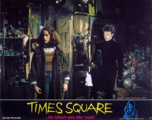 Trini Alvarado as Pamela Pearl and Tim Curry as Johnny LaGuardia Text at bottom: schröder-filmverleih TIMES SQUARE ...ihr könnt uns alle 'mal!! FSK FREIGEGEBEN