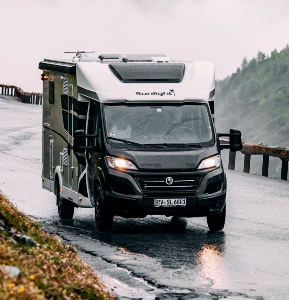 Camper auf Nasser Straße, im Hintergrund Nebel