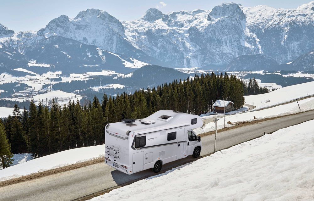 Wohnmobil mieten Stuttgart – Seitlicher und hinterer Blick auf den fahrenden Alkoven.