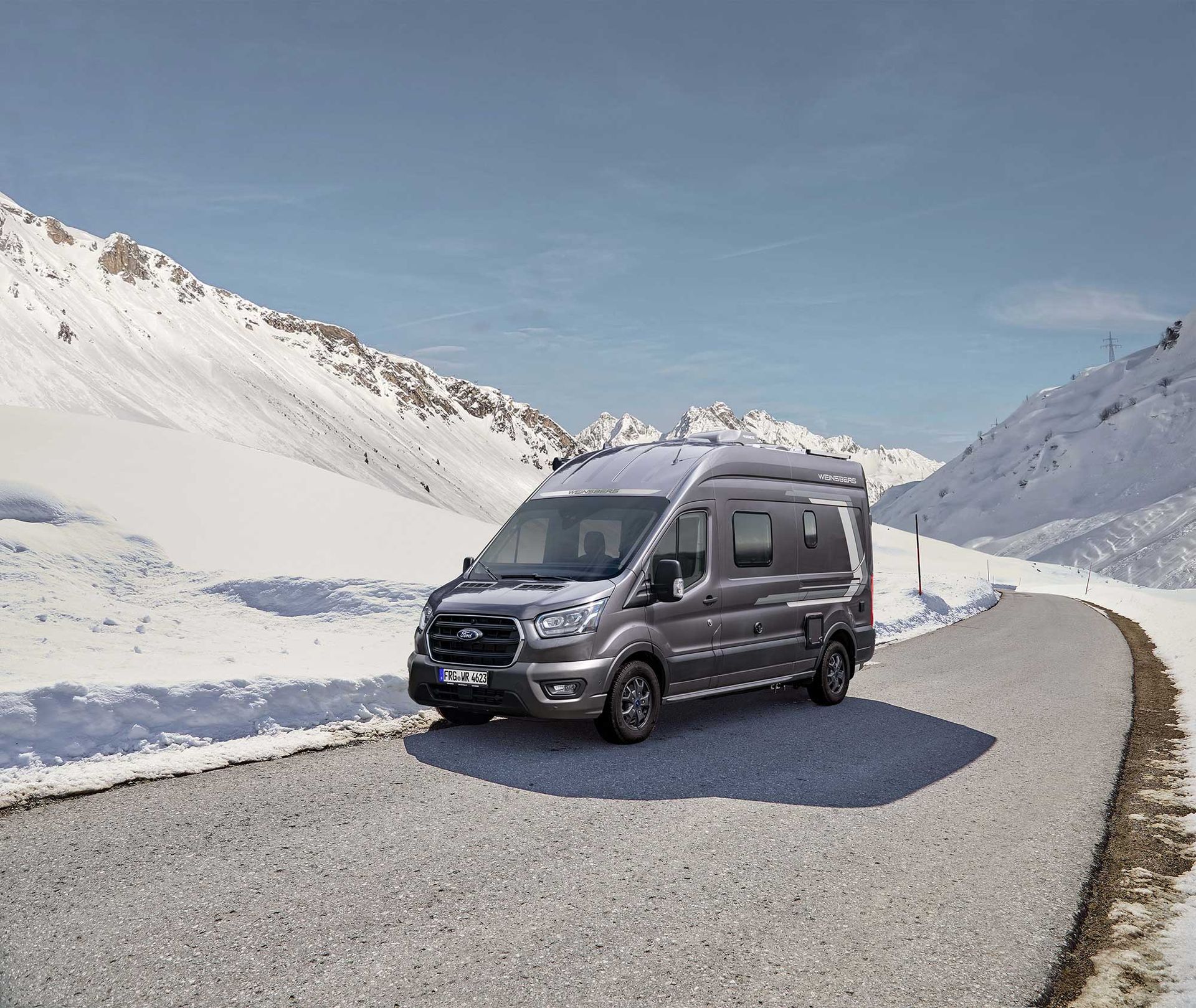 Ford Wohnmobil auf Straße zwischen Schneebergen