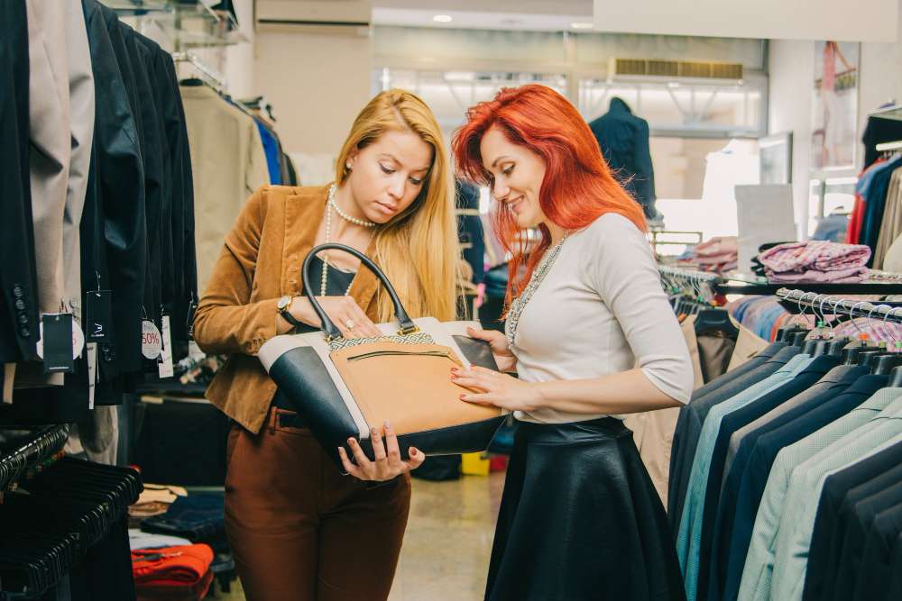 Two women shopping for a handbag at a consignment shop.
