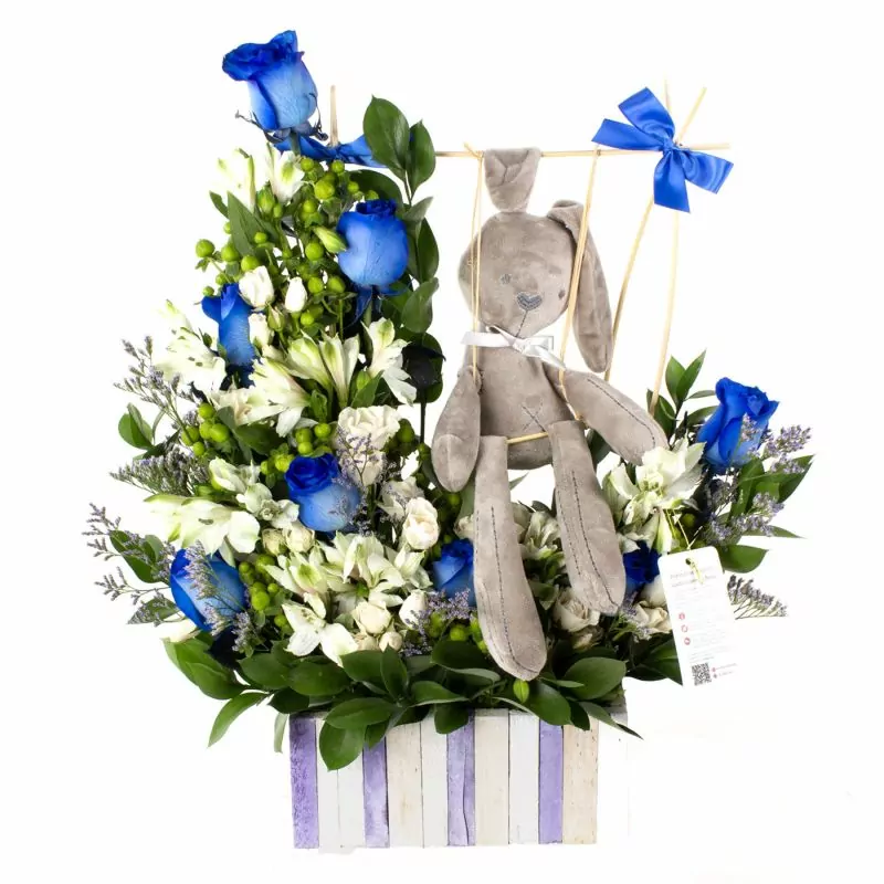 Conejito en el jardín - Arreglo floral con rosas azules, mini rosas blancas, hypericum, astromelias y peluche de conejito