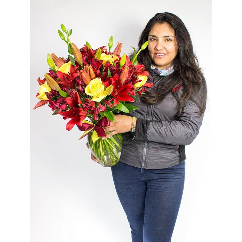Foto con persona Florero con Lilium rojos y rosas amarillas - Flores a domicilio Foto con persona Florero con Lilium rojos y rosas amarillas - Flores a domicilio