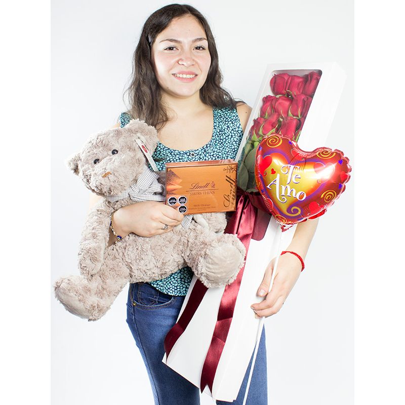 Foto con persona Caja con 12 rosas rojas mas Osito Teddy más globo varilla te amo y Lind Swiss Thins milk orange 125g - Flores a domicilio Foto con persona Caja con 12 rosas rojas mas Osito Teddy más globo varilla te amo y Lind Swiss Thins milk orange 125g - Flores a domicilio