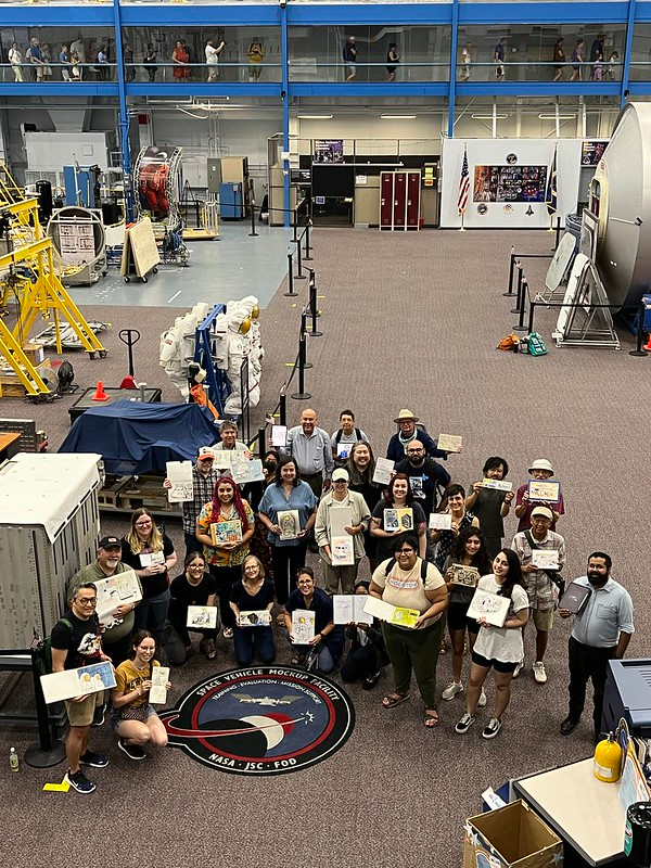 A group of artists pose with their sketches