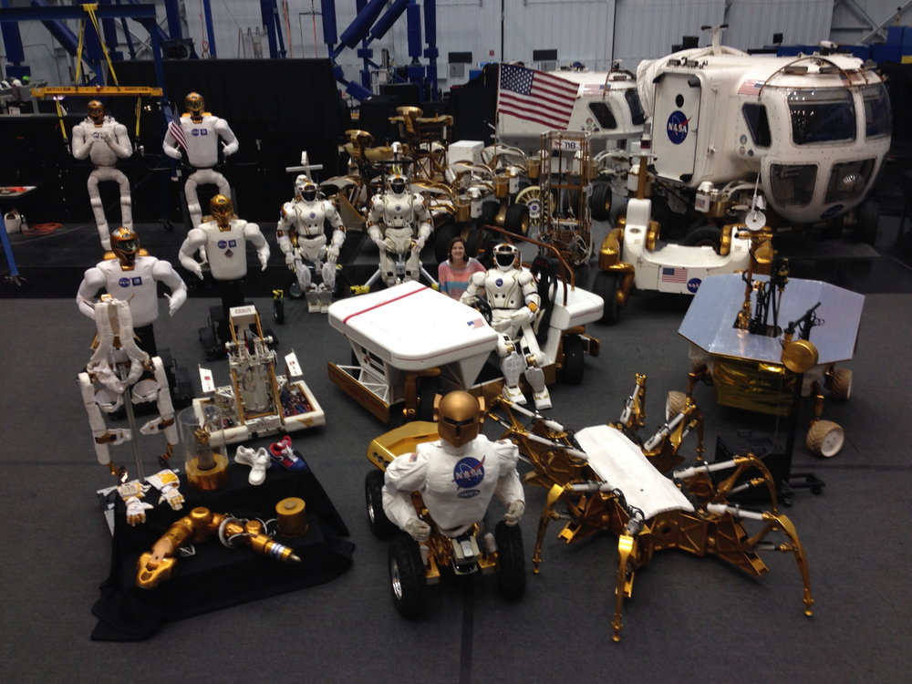 A woman in a facility surrounded by robots. 