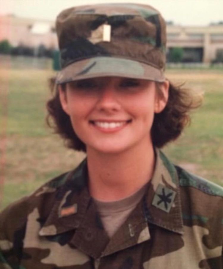 A woman wearing U.S. Army fatigues and a hat.