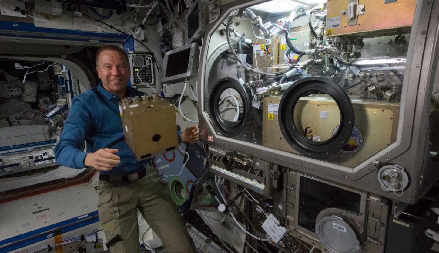 NASA astronaut Tim Kopra stows hardware from the OASIS experiment aboard the International Space Station. OASIS, which stands for Observation and Analysis of Smectic Islands In Space, studies the unique behavior of liquid crystals in microgravity. Credits: NASA