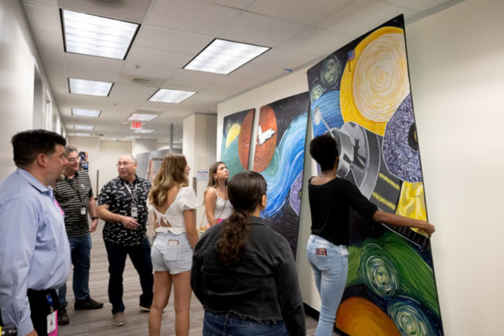 Students from Dickinson High School work together to install their art mural on the third floor in Building 4S at NASA’s Johnson Space Center. The artwork is displayed in the hallway outside of Room 3419, where it will remain indefinitely. Credit: NASA/Josh Valcarcel