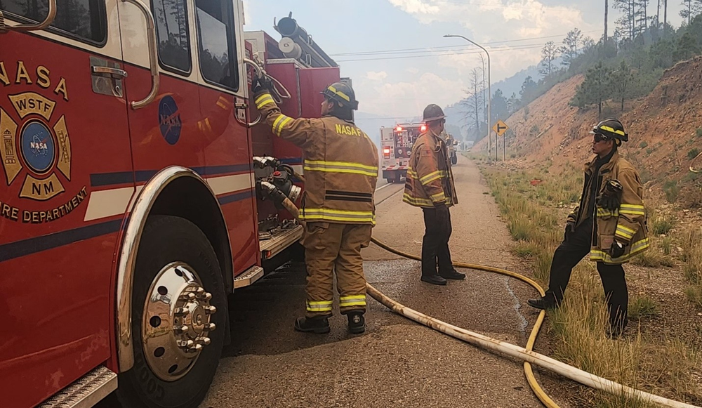 Members of the White Sands Fire Dept. prepare a fire engine on the side of the road.