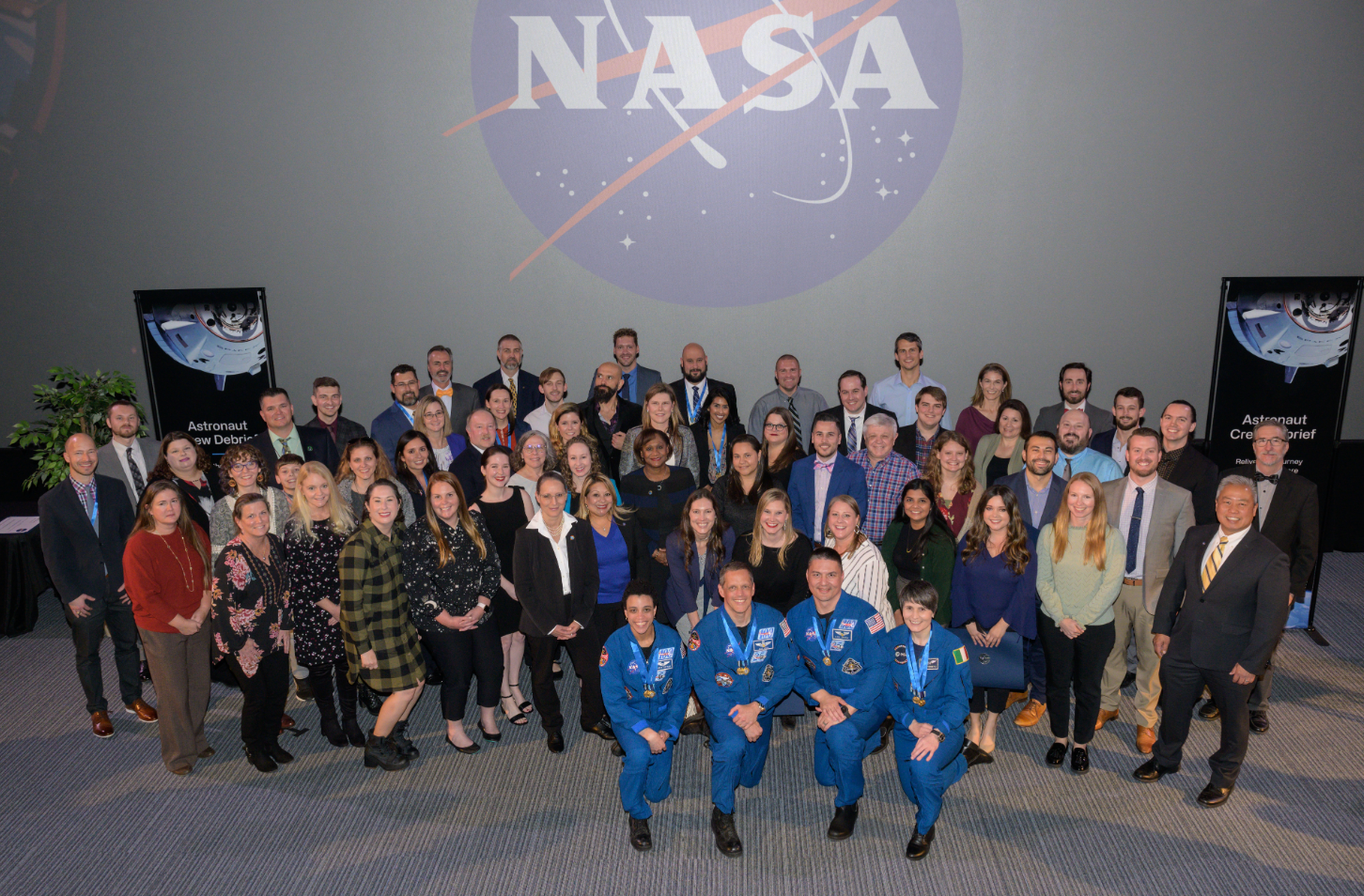 Expedition 67 NASA astronauts Jessica Watkins, Bob Hines, Kjell Lindgren, and ESA (European Space Agency) astronaut Samantha Cristoforetti, (pictured from left to right, kneeling, center) are surrounded by spaceflight mission award recipients, flight directors, and leadership at Space Center. The international crew shared highlights from their recent 170-day International Space Station expedition with the public and helped recognize key contributors to their mission success in an award ceremony immediately following the free, public event. Credits: NASA/James Blair