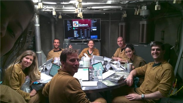 Subjects enjoying each other’s company, relaxation time, and quality music (courtesy of astronaut Christina Koch’s playlist) following completion of multiple surveys and assessments of appetite, food system acceptability, and related measures after mealtime. Subjects, from left to right: Emily Matula, Karina Marshall Goebel, Brian Prejean, Chris Massina, Kate Suratt, Andrzej Stewart, Rihab Sadik, and Jeff Watters. 