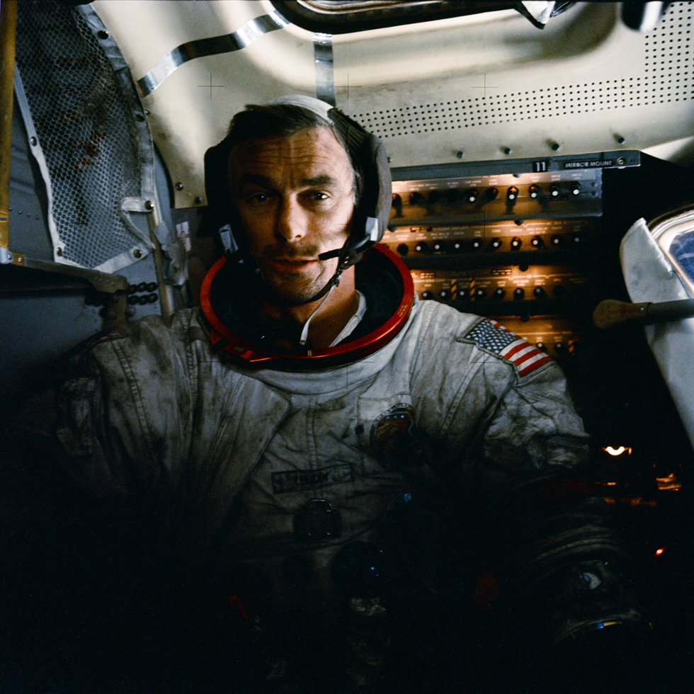 Apollo 17 mission commander Eugene Cernan inside the lunar module on the moon after his second moonwalk of the mission. His spacesuit is covered with lunar dust. 