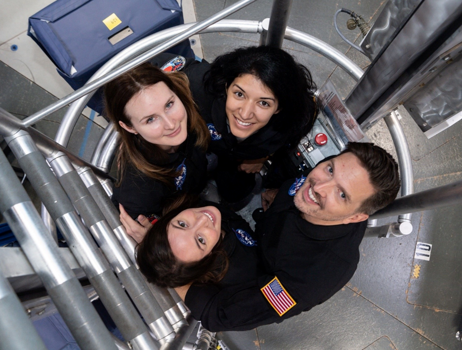 The crew of NASA's Human Exploration Research Analog Campaign 6 Mission 1 looks up from inside the habitat’s ladder well to say hello. From left to right: (top row) Lauren Cornell and Monique Garcia; (bottom row) Madelyne Willis and Christopher Roberts. Credits: NASA