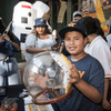 People pose for pictures and visit an informational booth during a baseball game.