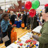 Groups of people enjoy a variety of indoor and outdoor exhibits and displays during a safety and health fair.