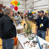 Groups of people enjoy a variety of indoor and outdoor exhibits and displays during a safety and health fair.