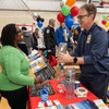 Groups of people enjoy a variety of indoor and outdoor exhibits and displays during a safety and health fair.