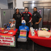 Groups of people enjoy a variety of indoor and outdoor exhibits and displays during a safety and health fair.