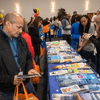 Groups of people enjoy a variety of indoor and outdoor exhibits and displays during a safety and health fair.