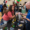 Groups of people enjoy a variety of indoor and outdoor exhibits and displays during a safety and health fair.