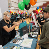 Groups of people enjoy a variety of indoor and outdoor exhibits and displays during a safety and health fair.