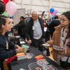 Groups of people enjoy a variety of indoor and outdoor exhibits and displays during a safety and health fair.