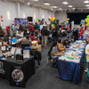 Groups of people enjoy a variety of indoor and outdoor exhibits and displays during a safety and health fair.