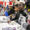 Photos of children and their families enjoying a holiday event that featured NASA astronauts and activities.