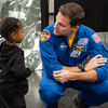 Photos of children and their families enjoying a holiday event that featured NASA astronauts and activities.