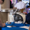 People gather together around a television in a cafeteria.