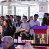 People gather together around a television in a cafeteria.