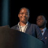 Students give a presentation on the stage in an auditorium. 